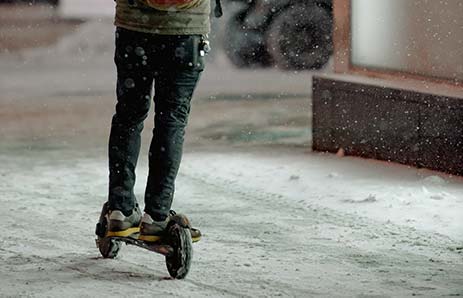 Osoba jadąca na hulajnodze elektrycznej